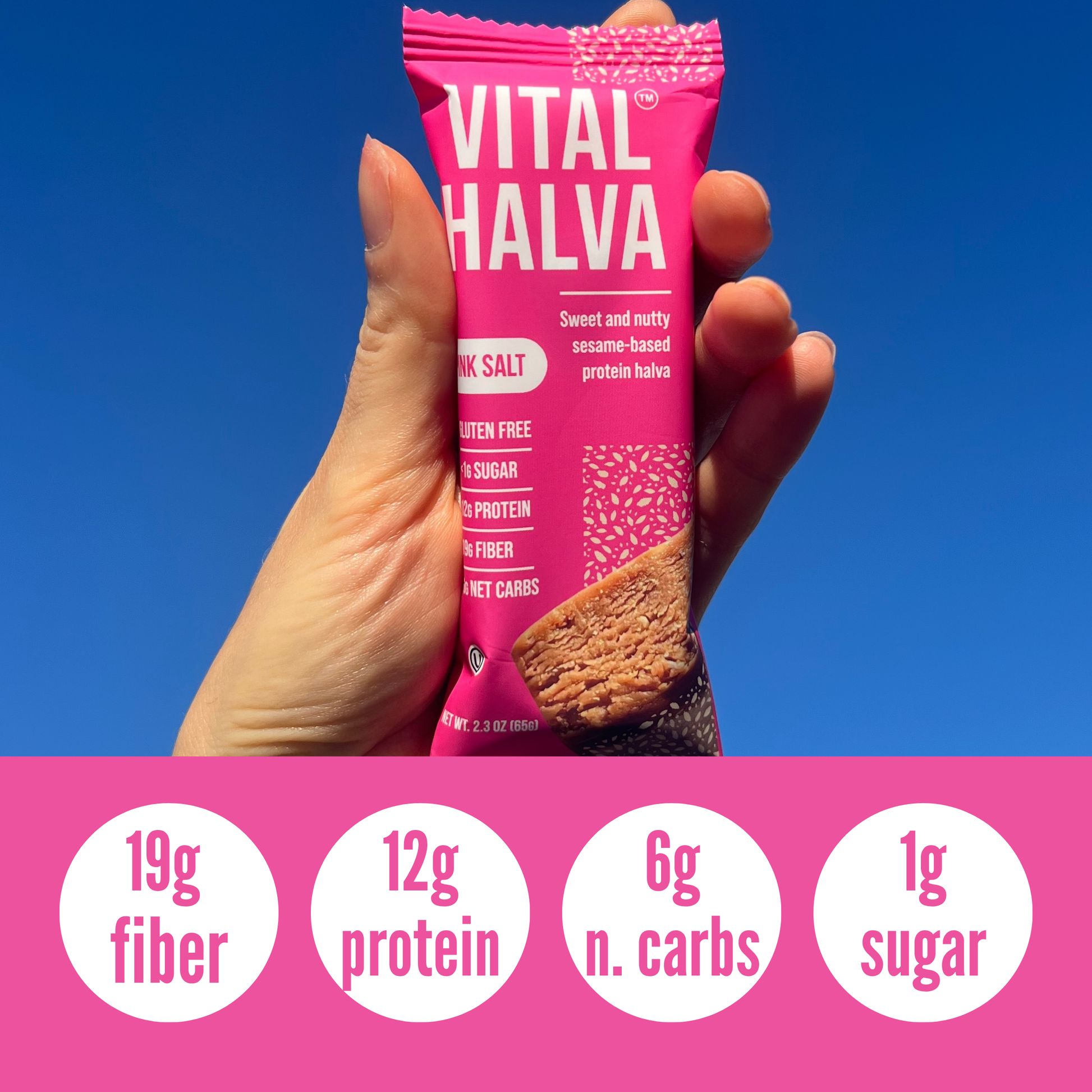 Hand holding a pink 'Vital Halva' bar with nutritional information on a blue background